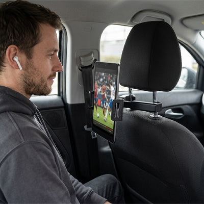 Passager assis en arriÚre regarde football sur tablette fixé sur support tablette voiture