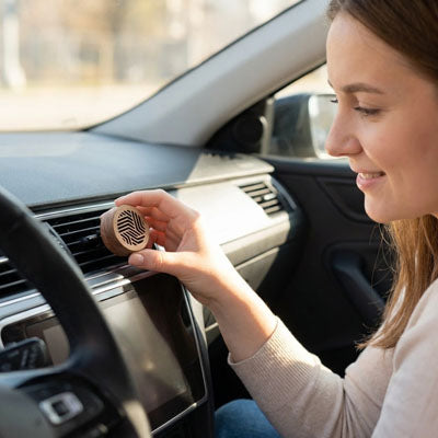 Conductrice heureuse installe diffuseur de parfum dans grille aération