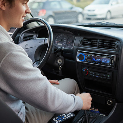 Conducteur écoute musique via autoradio bluetooth avec télécommande dans habitacle voiture