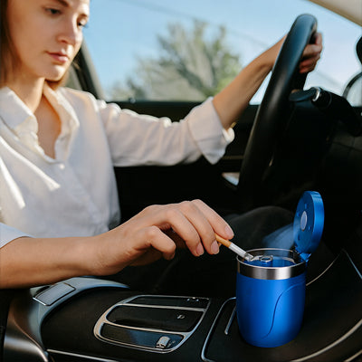 Conductrice dépose cendre cigare dans cendrier pour voiture bleu  installé dans console centrale véhicule.