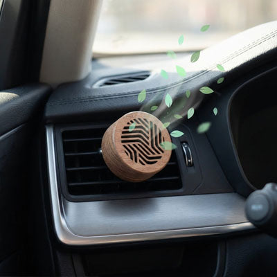 Diffuseur de parfum fixé dans grille d'aération du tableau de bord diffuse