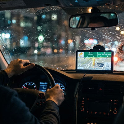 gps voiture affichant navigation nocturne sous pluie en conduite
