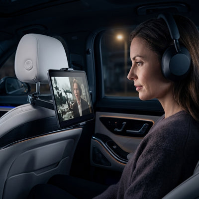 Passager écoute émission avec casque connecté a son tablette installé sur support tablette pour voiture 