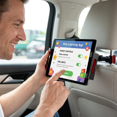 Passager souriant en travaillant sur tablette installé sur support tablette pour voiture