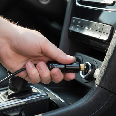 prise allume cigare en main entrain d' être branchée