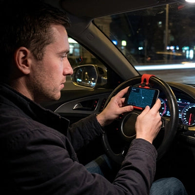 Support telephone voiture fixé au volant avec smartphone affichant GPS pour conducteur la nuit