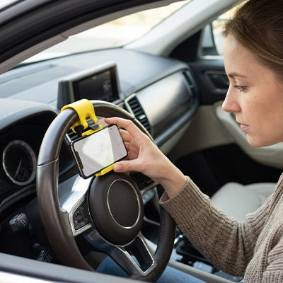 Support telephone voiture fixé au volant avec smartphone affichant GPS pour conductrice 